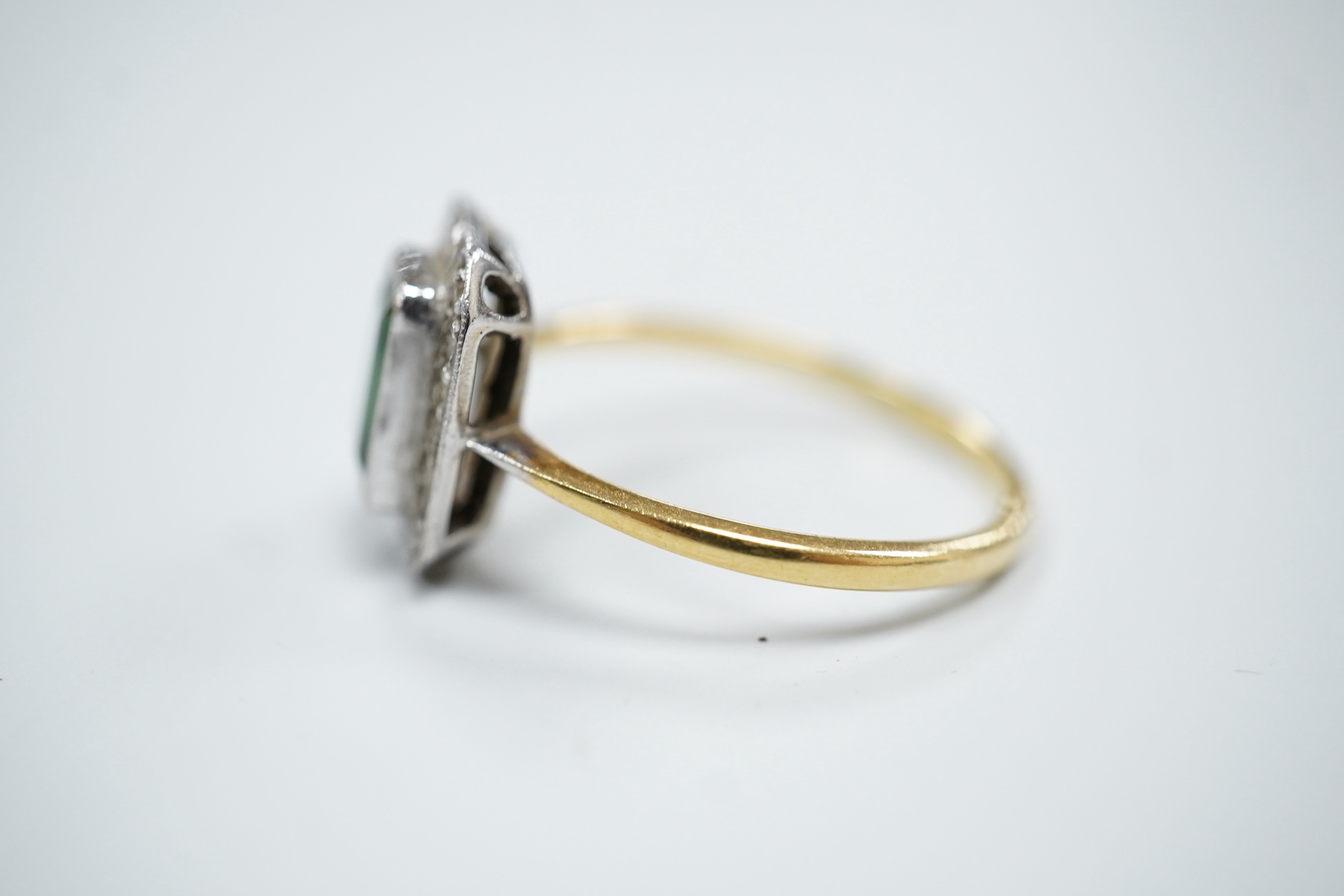 A yellow metal, green tourmaline and diamond set octagonal cluster ring, in a millegrain setting, size R, gross weight 3 grams.
